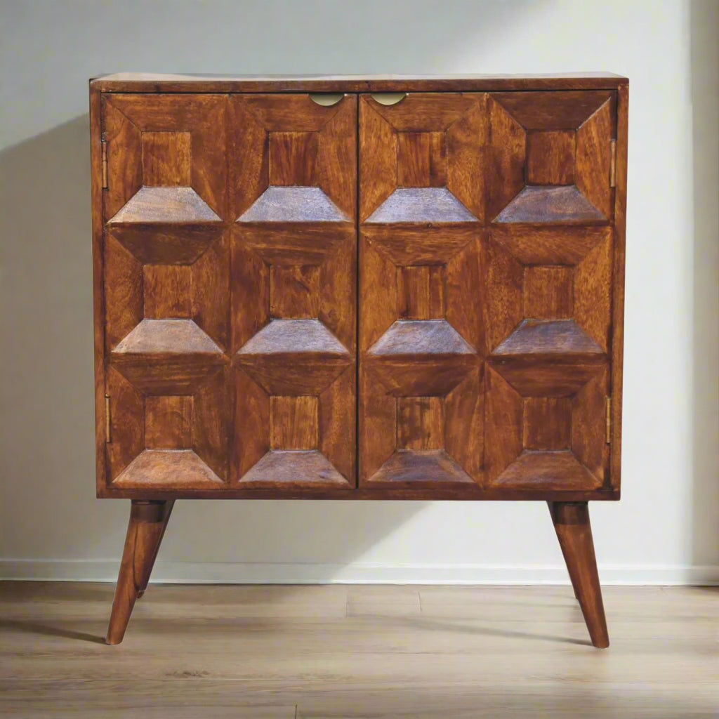 A wooden quad cabinet with cut-out geometric designs on the doors, finished in a warm chestnut color, standing on Nordic-style legs.